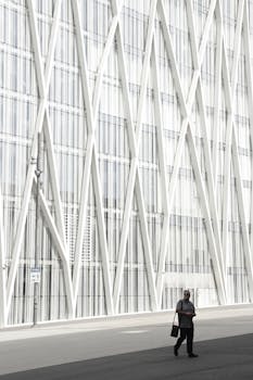 Urban scene featuring contemporary architectural design with geometric facades and a solitary pedestrian.