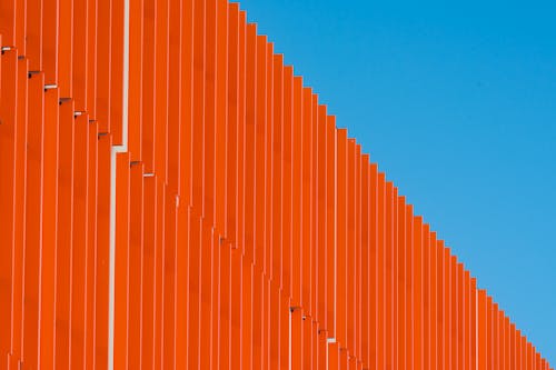 A close up of an orange wall with a blue sky