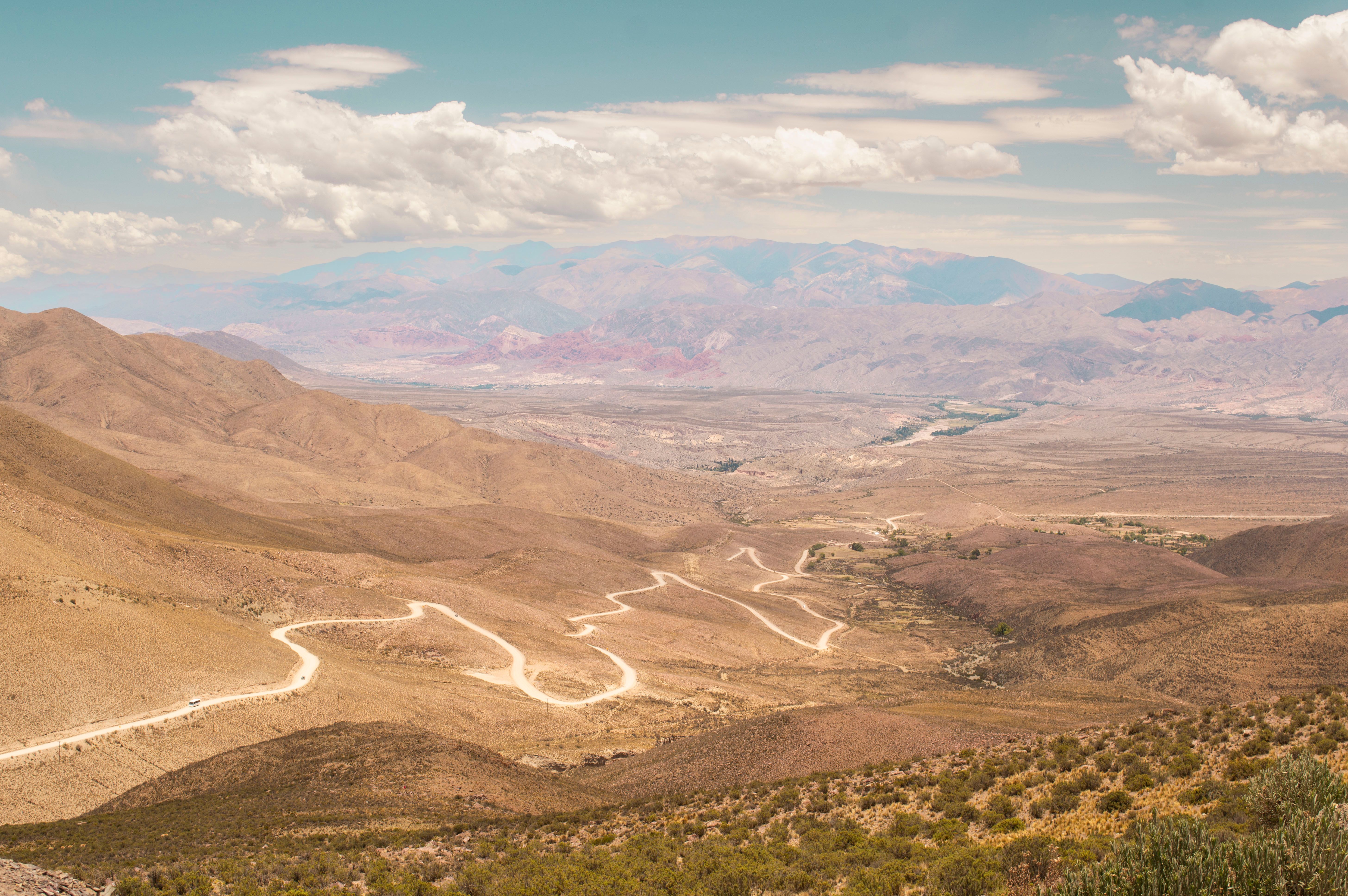 Explore the winding roads of Jujuy, Argentina in this expansive desert landscape under a clear sky.