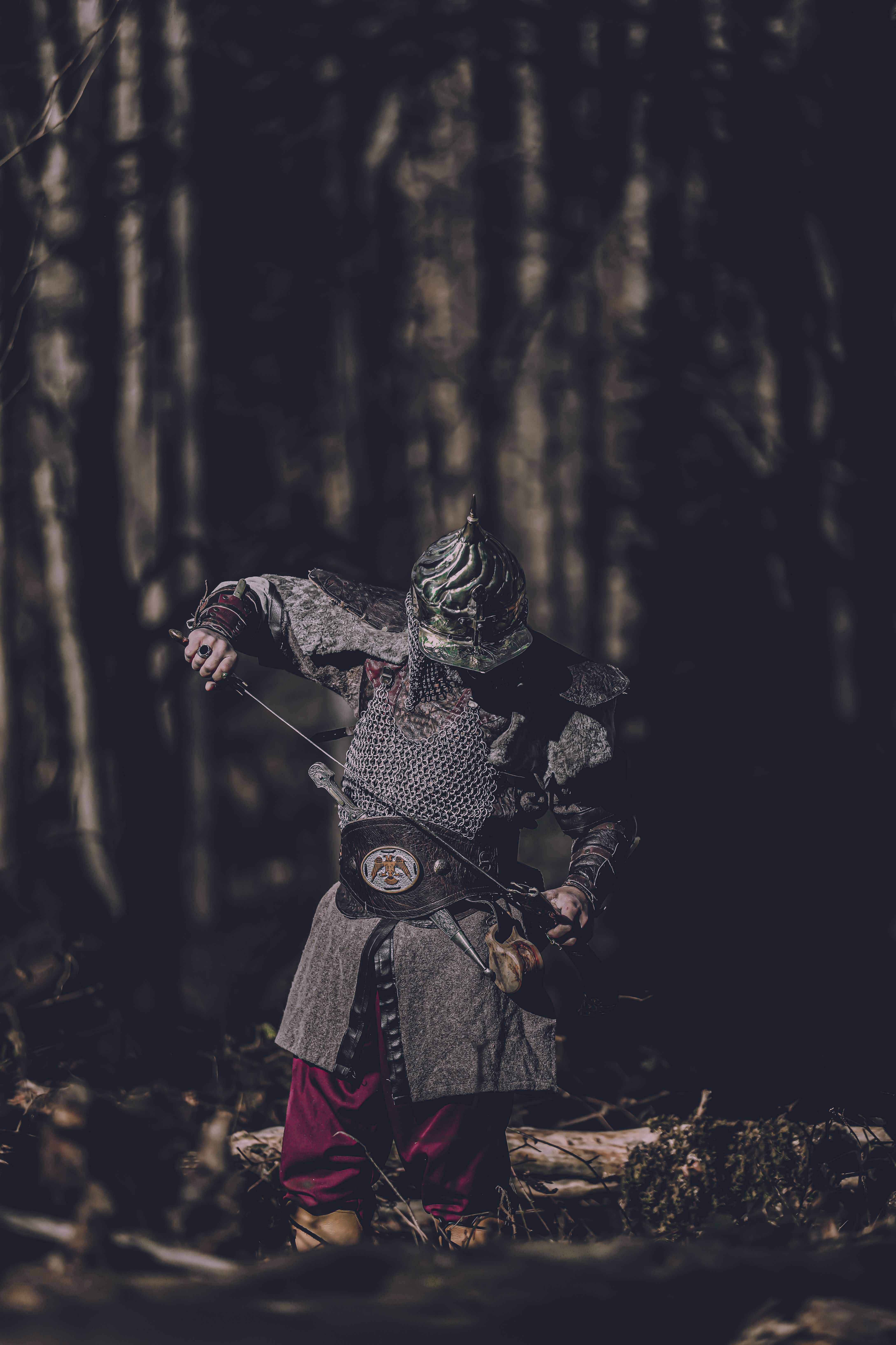 Armoured warrior drawing a blade in a dark winter forest — photo by Ahmet Mert on Pexels