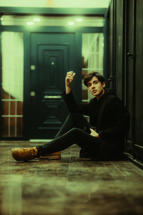 A man sitting on the floor in front of a door