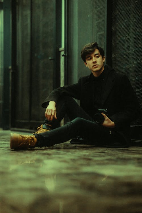 A man sitting on the floor in a dark room