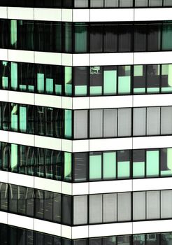 Close-up view of a modern glass and steel office building facade with reflective windows.