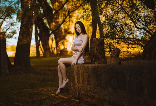 A woman sitting on a rock in the middle of a field