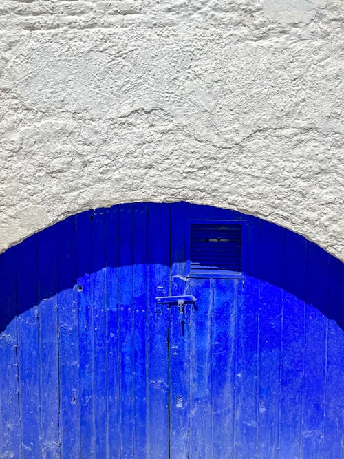 A blue door with a white wall and a blue door