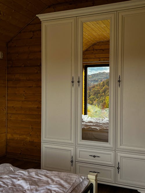 A bedroom with a large mirror and a large wardrobe