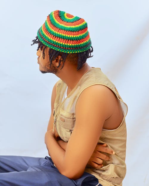 A man wearing a colorful hat sitting down