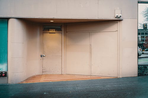 A man is walking down the sidewalk in front of a building