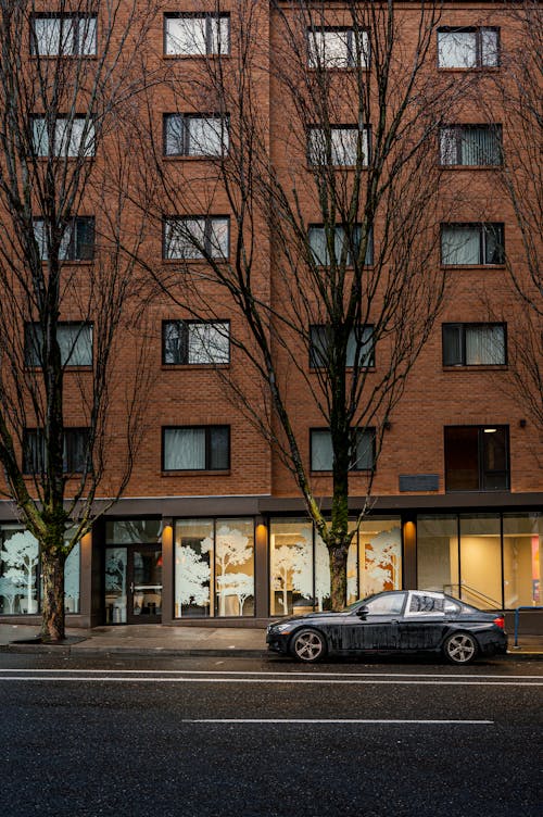 A car parked in front of a building with trees