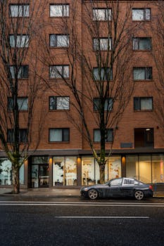 Urban street view of a brick apartment building with parked car in Portland, Oregon.