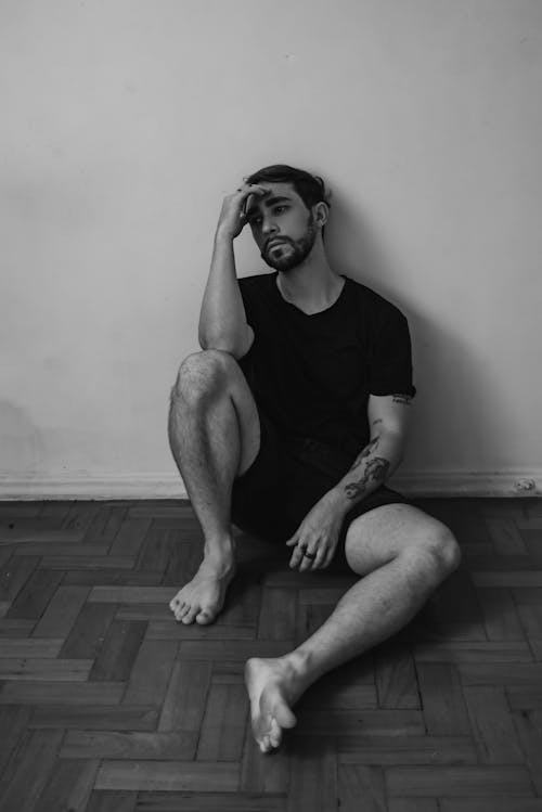 Barefoot Man in T-shirt Sitting in Black and White