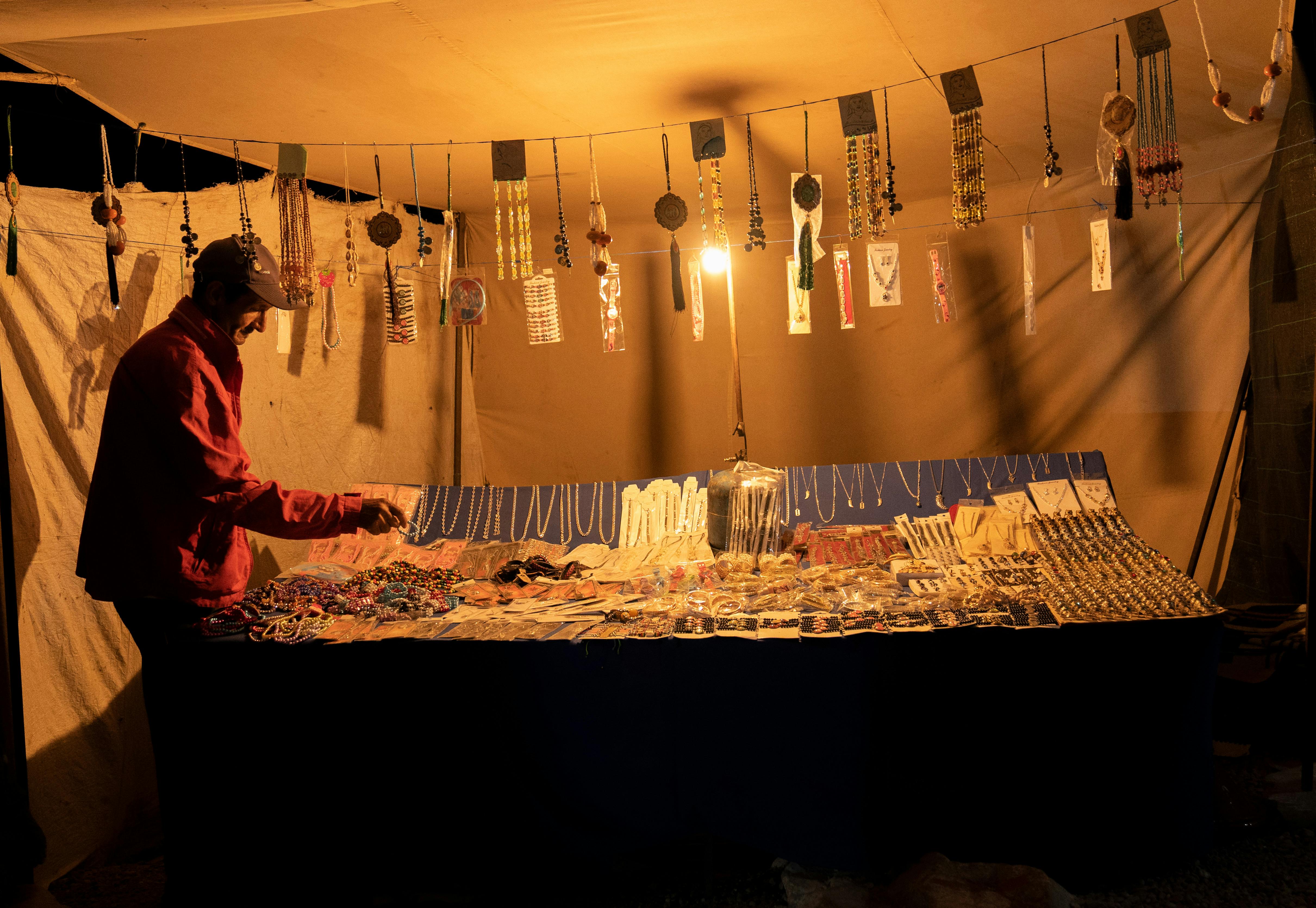 A vibrant night market stall in Tiznit, Morocco displaying handmade jewelry and crafts. - Tiznit