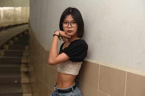 Asyalı kadın, ayakta, duvar içeren Ücretsiz stok fotoğraf