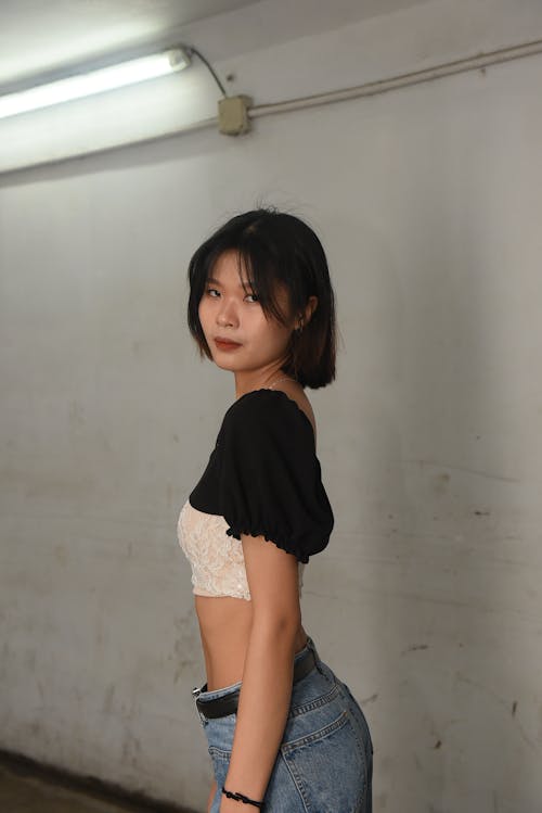 A young asian woman in jeans and a crop top
