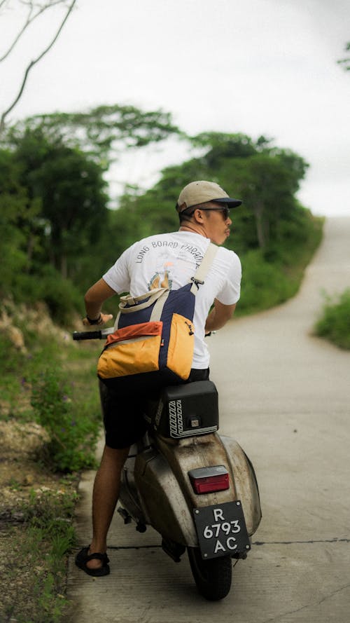 A man on a scooter with a backpack