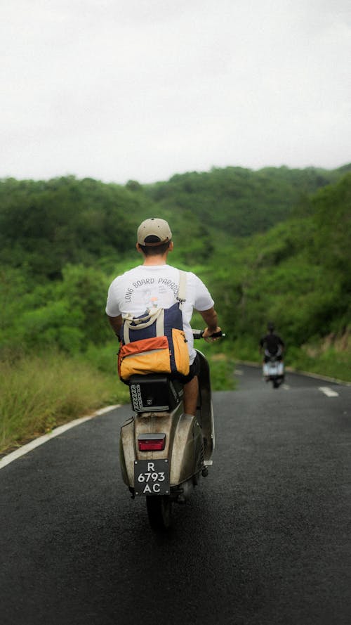 A man riding a motorcycle down a road