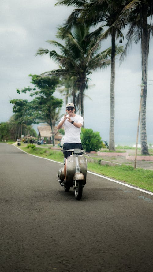 A man riding a scooter on a road