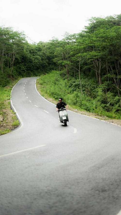 A person riding a motorcycle down a winding road