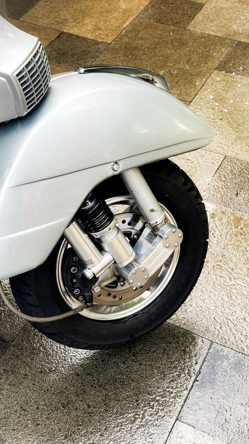 Detail eines Scooter-Rads mit Federung und Reifen