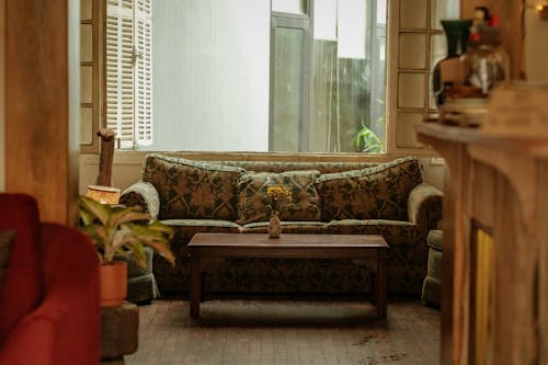 A living room with a couch, coffee table and a window