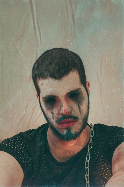 A man with a face painted with blood and chains