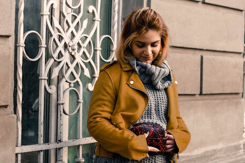 Vrouw Die Gele Trenchcoat Draagt Met Rode Handtas