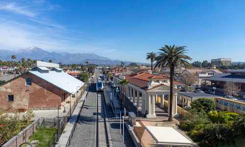 Free View of Redlands train station showcasing vibrant palm trees and mountainous backdrop. Stock Photo