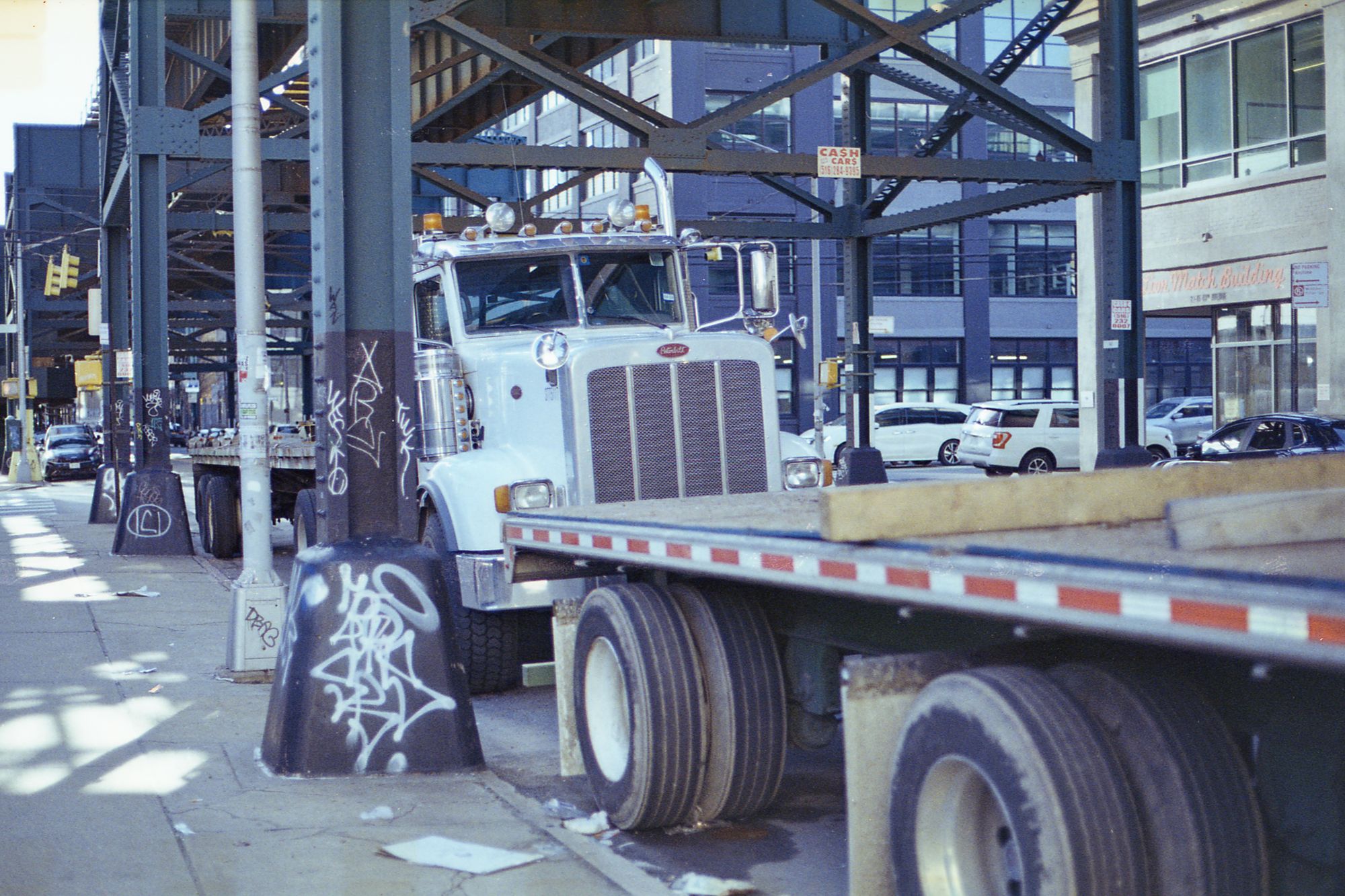 An open-deck trailer loaded with oversized timber logs secured for heavy-haul transport