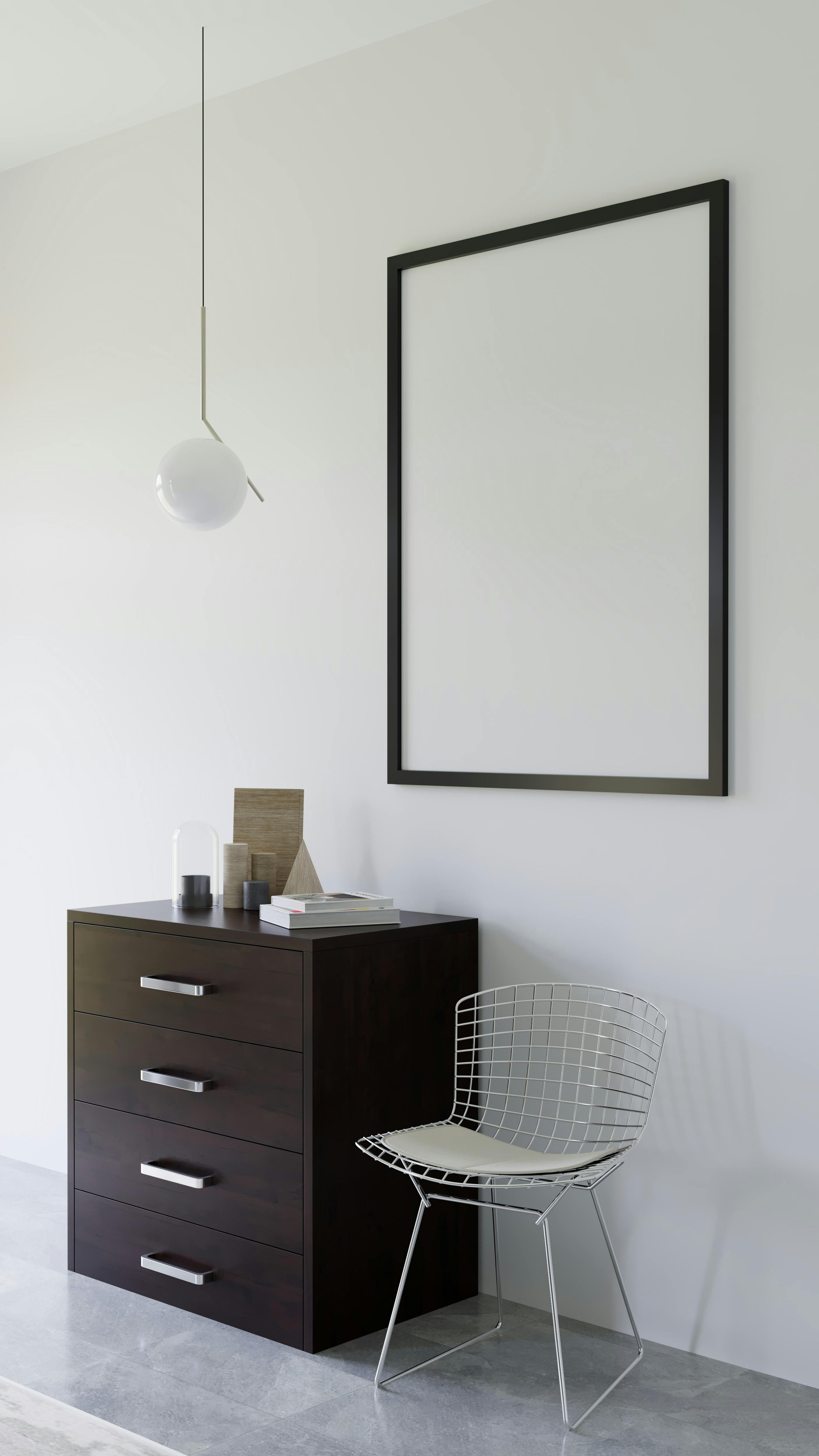 a white wall with a black frame and a chair