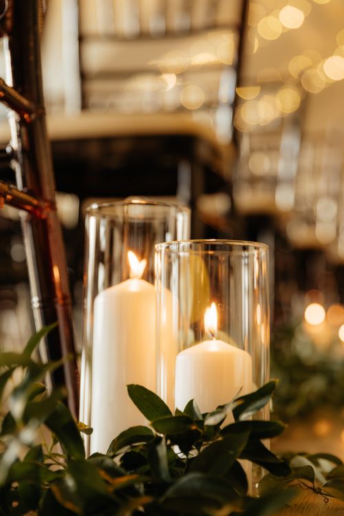Free Warm and cozy candlelit arrangement with lush green leaves in an indoor setting, capturing a serene ambiance. Stock Photo