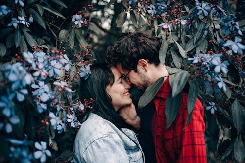 Free Man and Woman Standing Under Flowering Tree Stock Photo