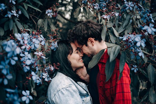 Happy couple sharing a romantic moment surrounded by beautiful blue flowers.