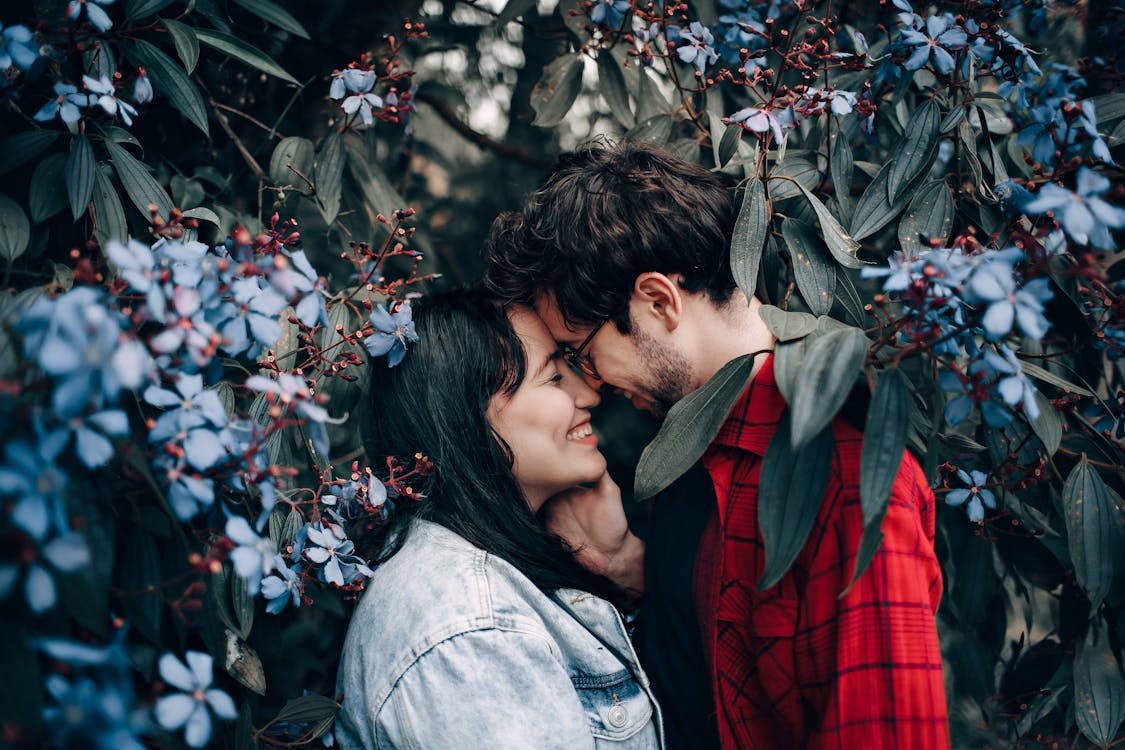 man and woman standing under flowering tree 