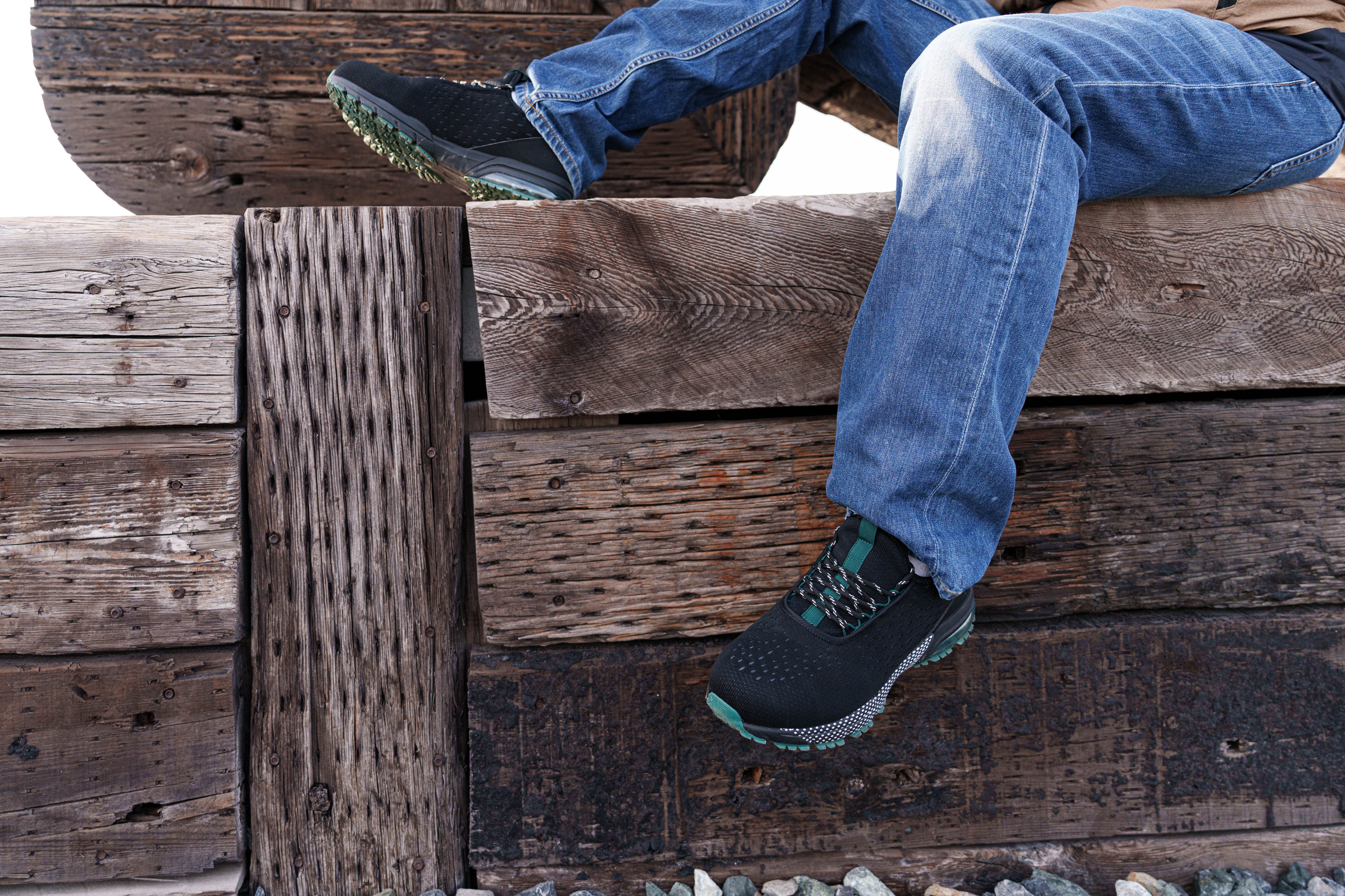 Casual jeans and sneakers resting on a rustic wooden bench, evoking a relaxed outdoor setting.