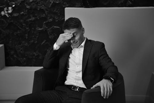 Black and White Photo of a Man in a Suit Sitting in an Armchair 