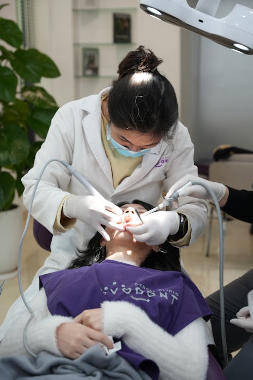 A woman getting her teeth cleaned by a dentist
