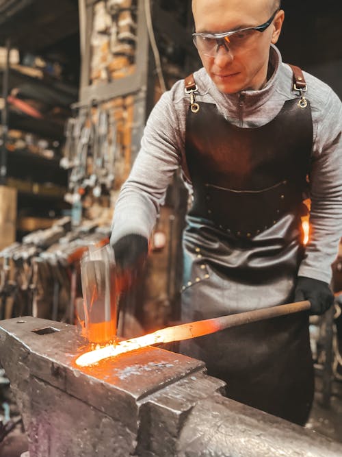 A man is working on a blacksmith's forge