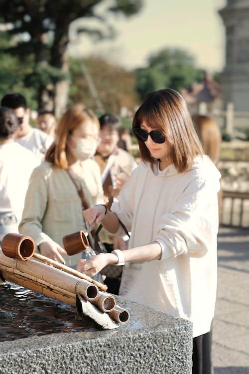 A woman is using a bamboo stick to make a bowl