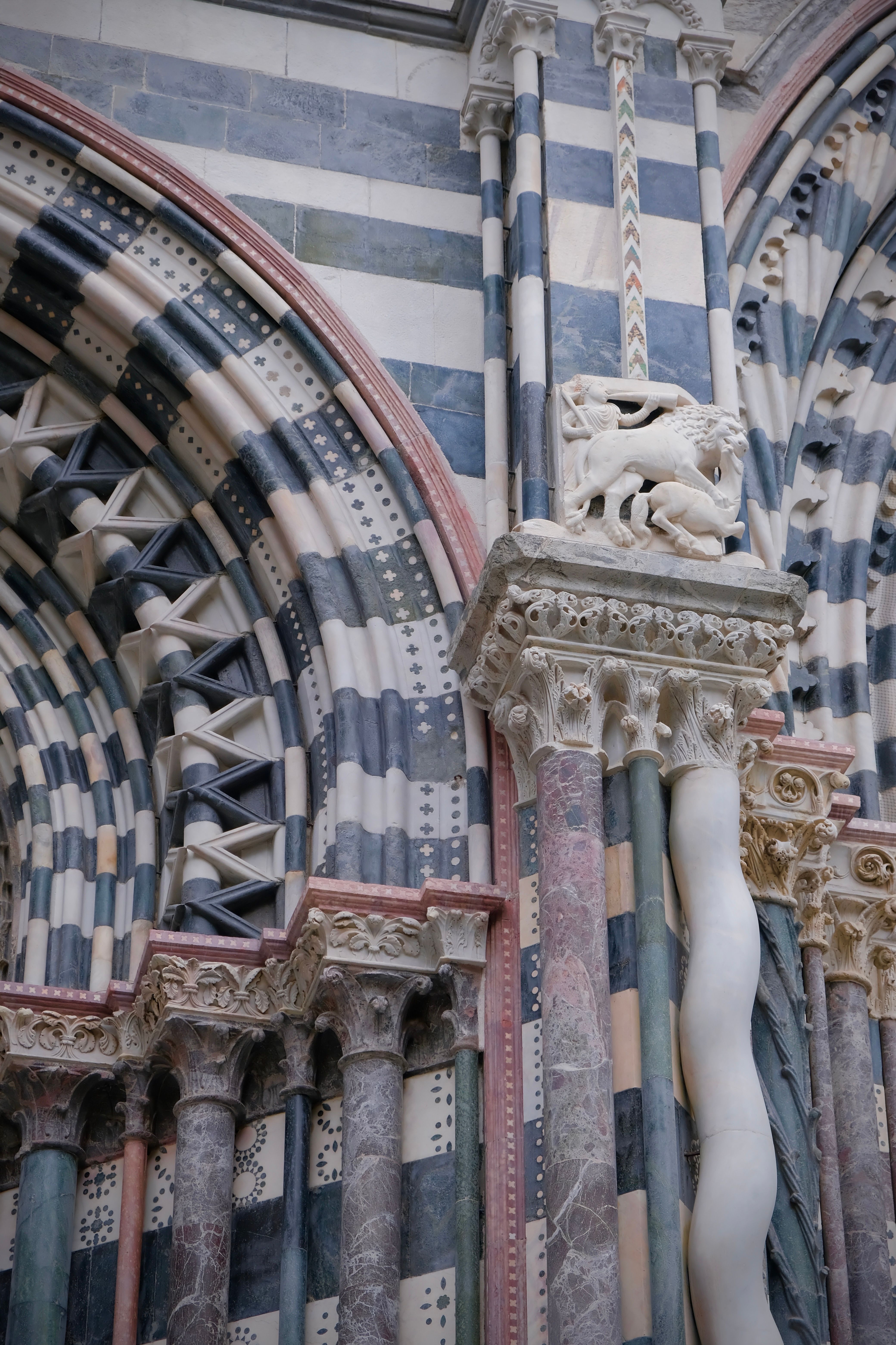 Close-up of the striped marble arch and columns of Genoa's Cattedrale di San Lorenzo.