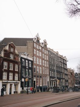 Elegant rowhouses line a historic street in Amsterdam, showcasing classic Dutch architecture.