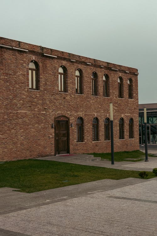 A brick building with windows and a grassy area