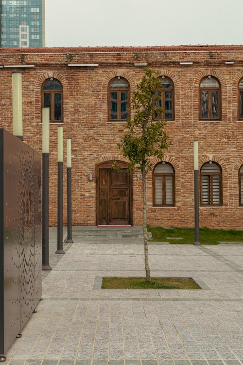 A brick building with a tree in front of it