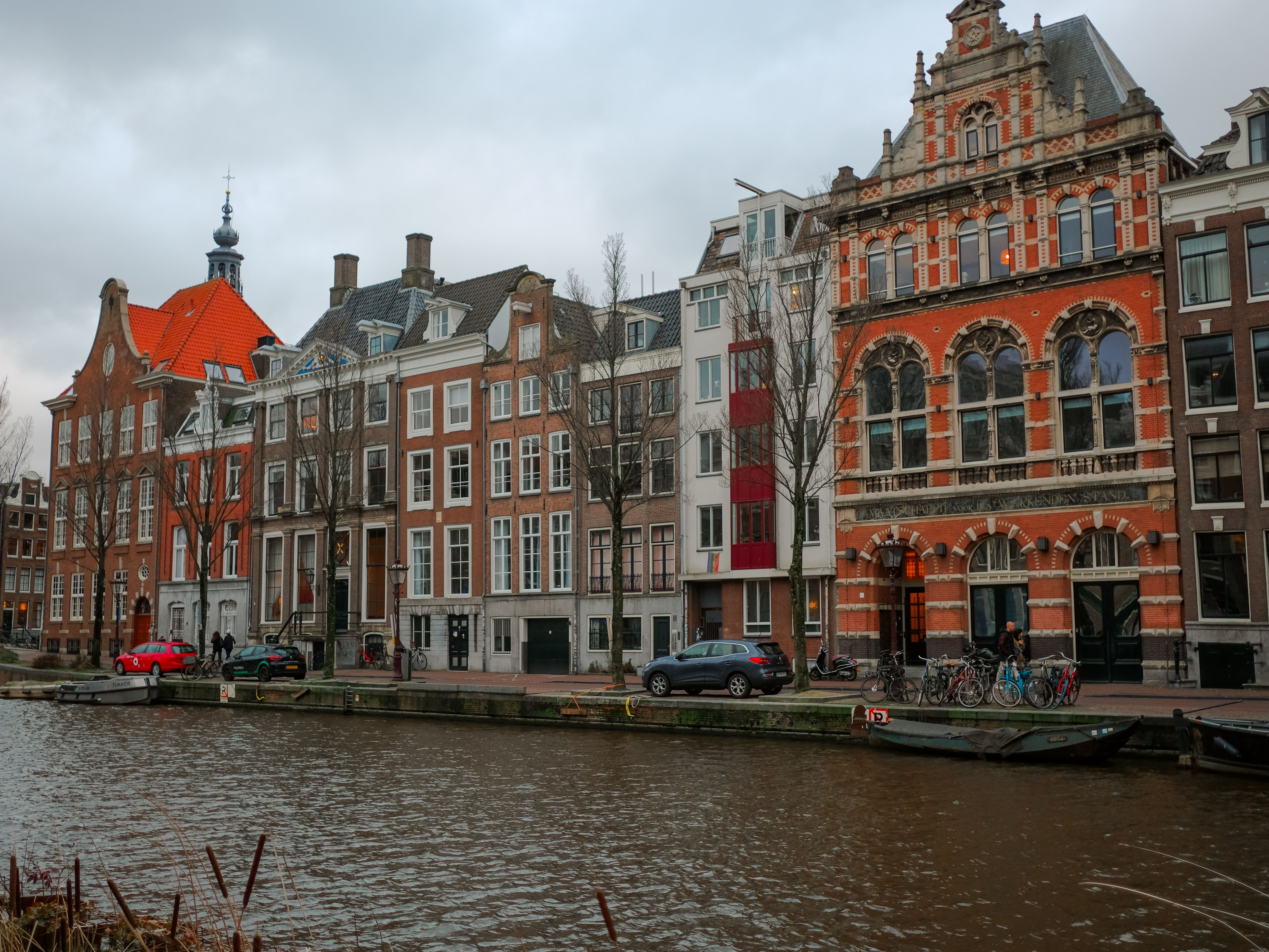 Wet cobbles and lit cellar bars along a Utrecht canal wharf on a winter evening