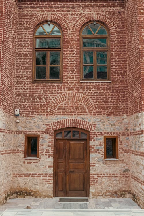 A brick building with a wooden door and windows