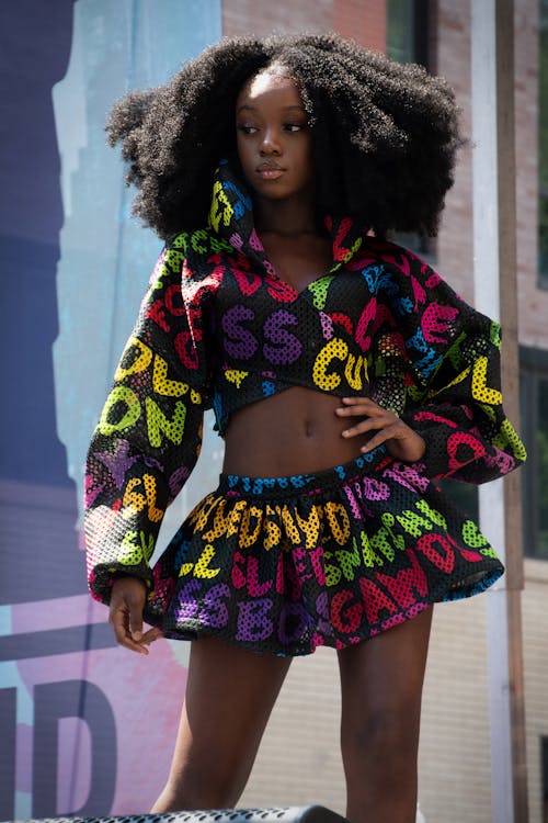 A woman with afro hair wearing a colorful outfit