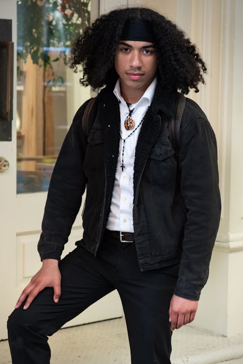 A man with long hair and a black jacket