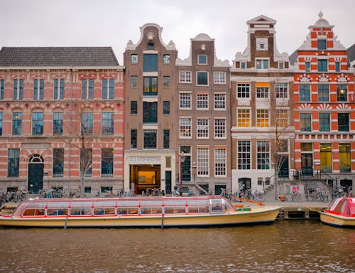 A boat is docked in front of a row of buildings