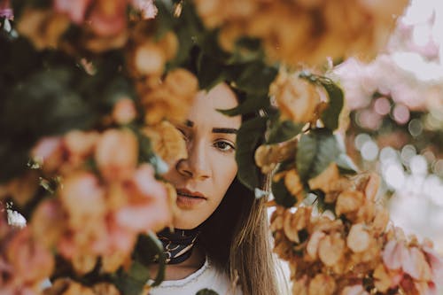 Woman Standing Under Beige-petaled Flowers