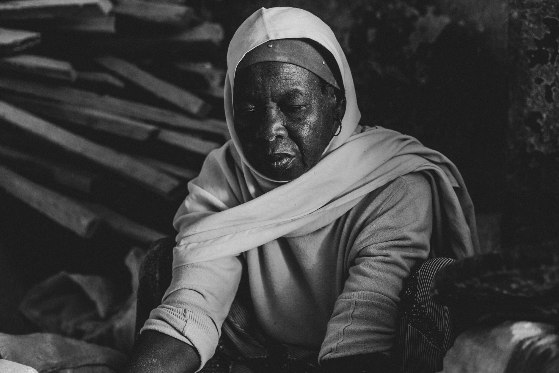 Elegant black and white portrait of a Nigerian woman sitting indoors, exuding grace and dignity.