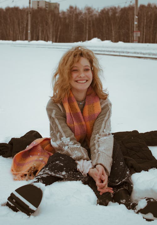 A woman sitting in the snow smiling